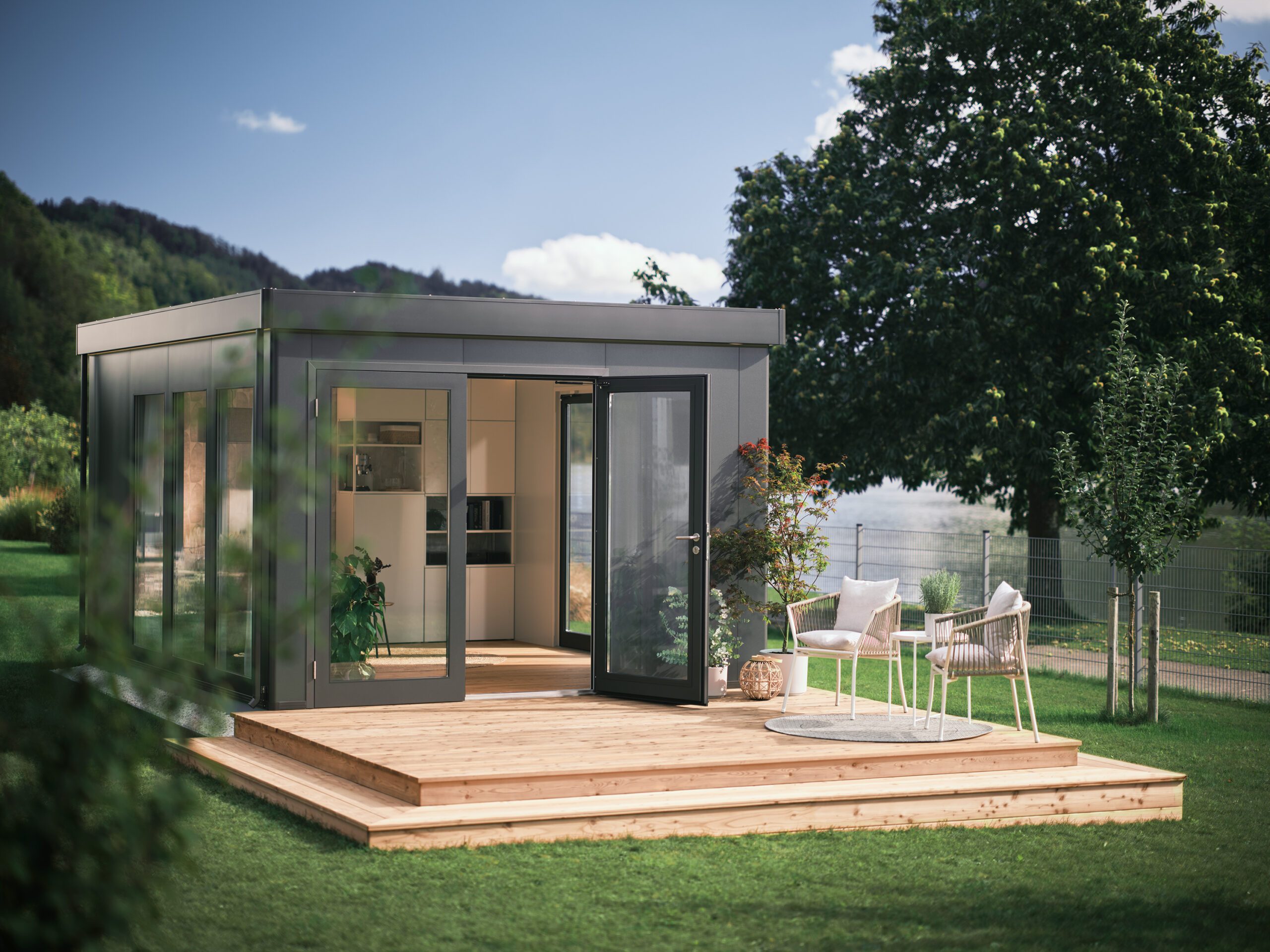 Dunkelgraues, modernes Gartenhaus und erweiterter Wohnraum mit Ganzglastüren, Fenstern und Flachdach in einem grossen Garten. Erweiterter Wohnraum kaufen Schweiz.