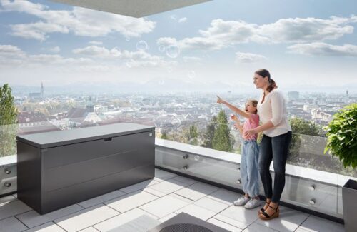 Die Biohort Stylebox in quarzgrau metallic geschlossen auf einer Terrasse mit Ausblick auf eine Stadt.